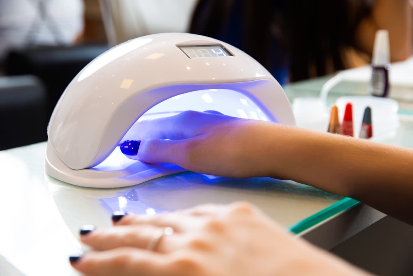 A gel manicure curing under an LED nail lamp